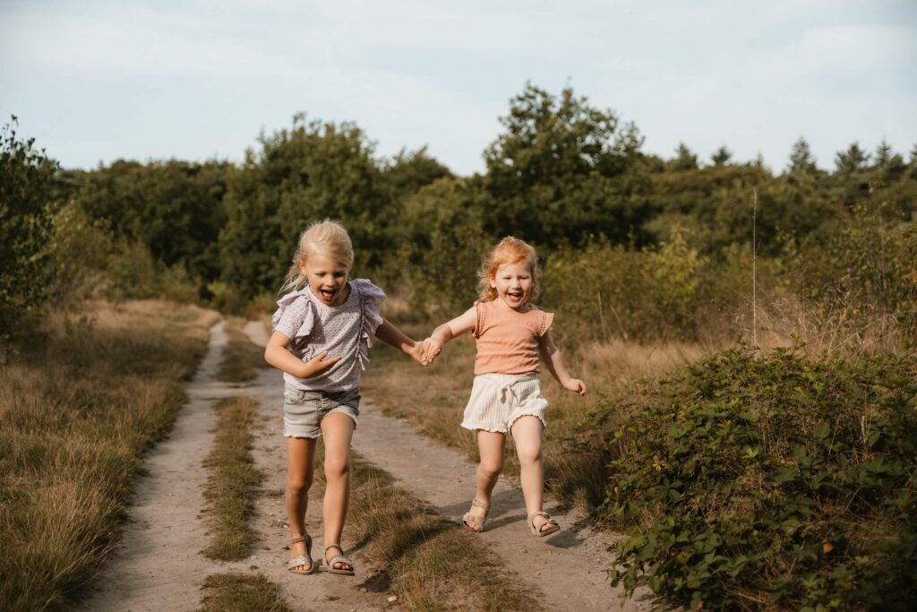 Zusjes rennen op Ginkelse Heide tijdens gezinsshoot in Ede
